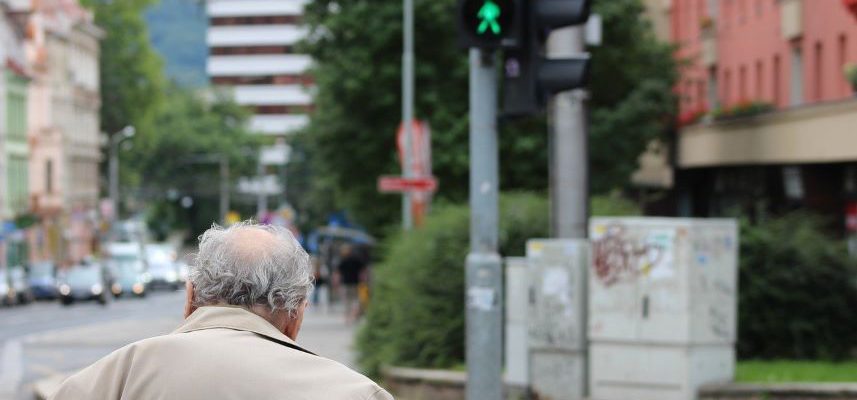 starszy mężczyzna przechodzący przez jezdnię